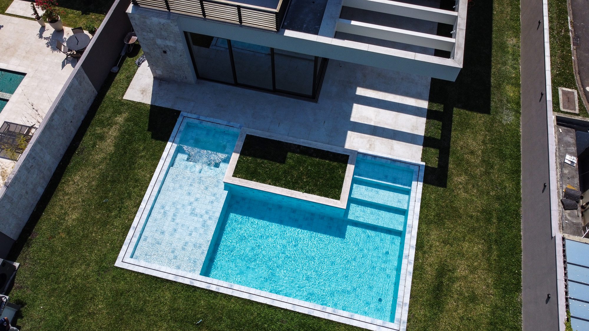 Vista aérea de piscina Naussat integrada à arquitetura de uma residência