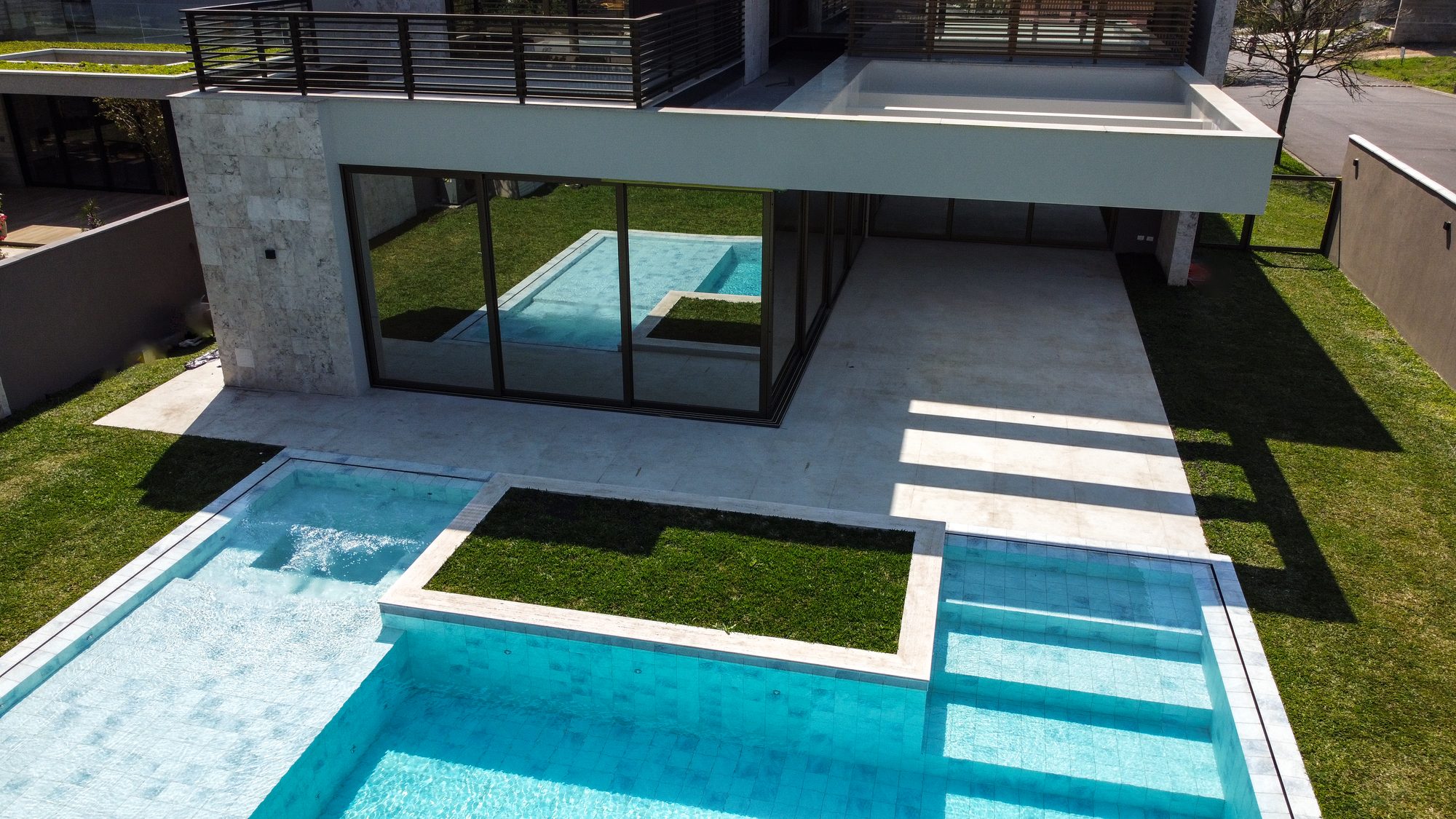 Vista aérea de piscina integrada à arquitetura da residência