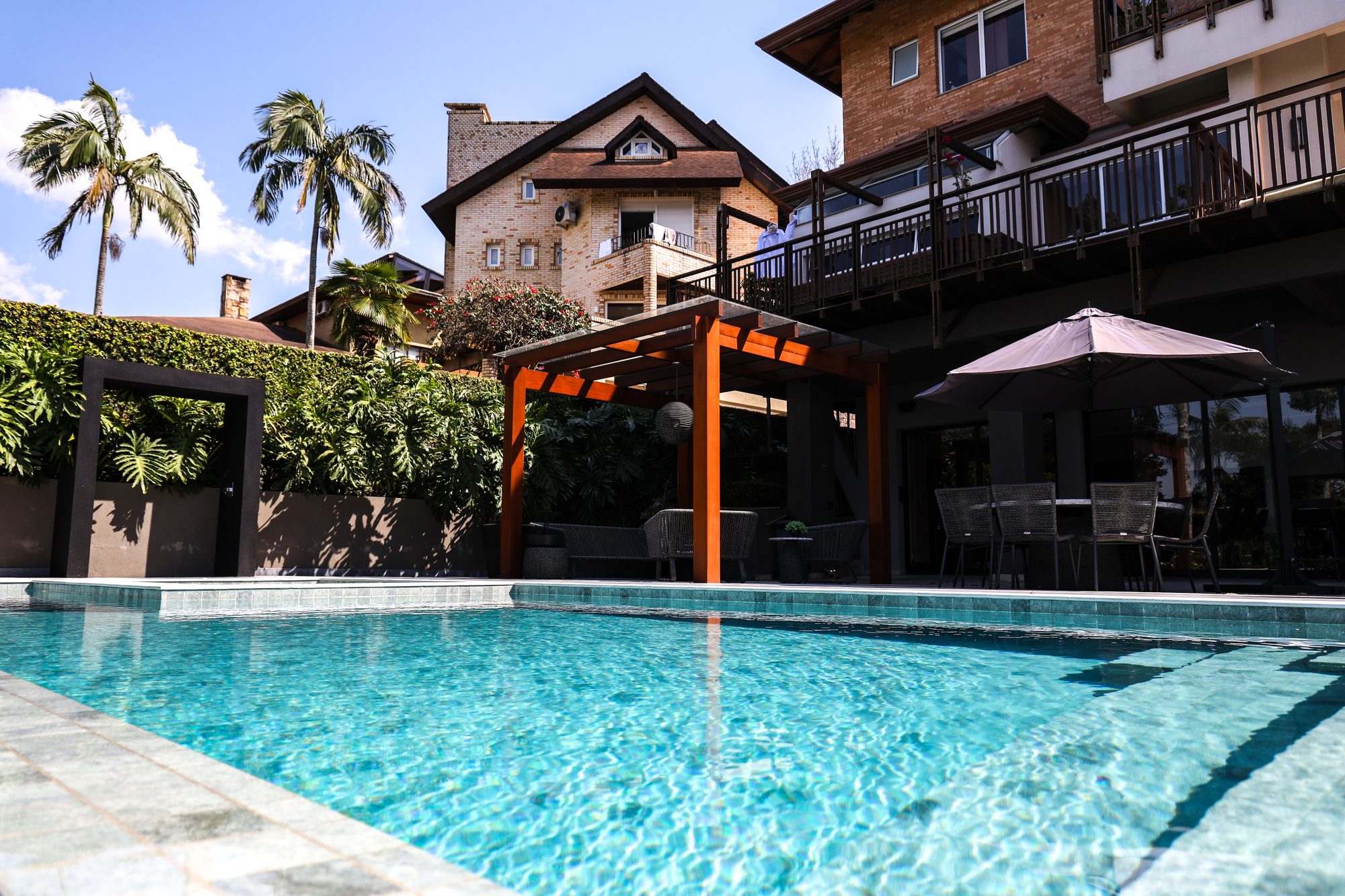 Piscina revestida em membrana de PVC armado com pergolado e área de convivência