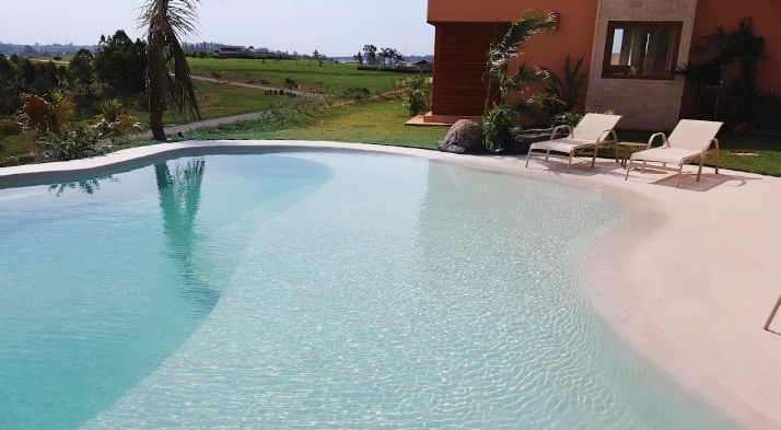 Piscina com revestimento monolítico claro e prainha